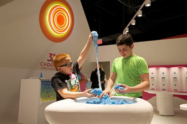 Brothers Noah, 10, left, and Ilan Weintraub, 12, of Atlanta, play in the slime containers at Sloomoo in Buckhead, Wednesday, November 16, 2022, in Atlanta. Jason Getz / Jason.Getz@ajc.com)