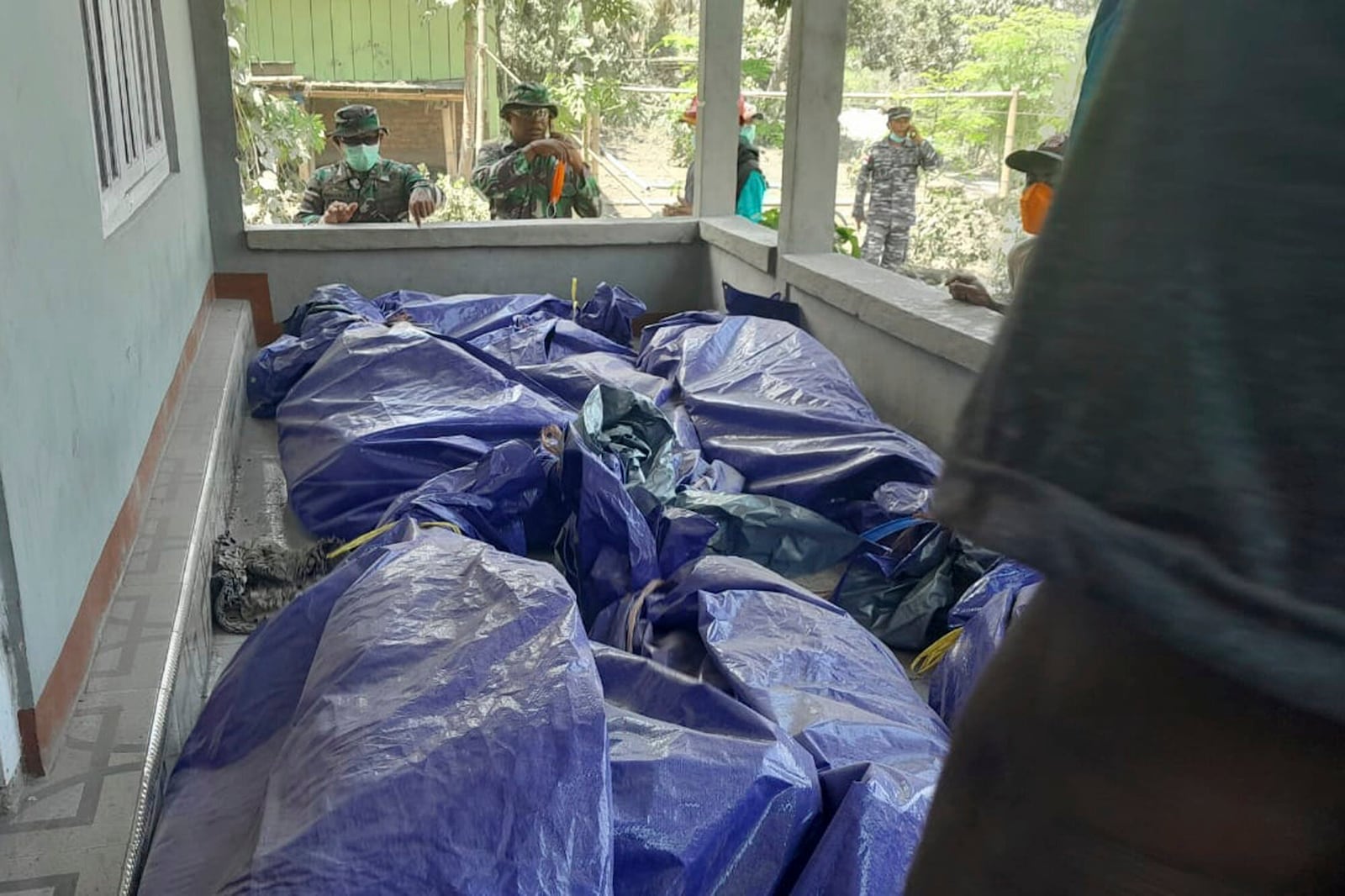 In this photo released by the Indonesian National Search and Rescue Agency (BASARNAS), rescuers inspect the bodies of the victims of the eruption of Mount Lewotobi Laki-Laki in East Flores, Indonesia on Monday, Nov. 4, 2024. (BASARNAS via AP)