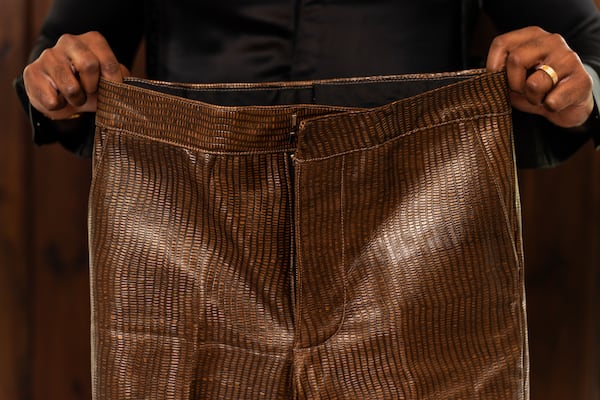 Tailor Carl Ulysses displays pants he made worn by Jamie Foxx in “They Cloned Tyrone” at The 500 Apartments in Atlanta on Friday, June 28, 2024. (Seeger Gray / AJC)