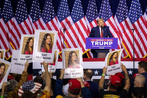 Republican presidential candidate and former President Donald Trump speaks about slain nursing student Laken Riley during a rally at Forum River Center in Rome on Saturday, March 9, 2024, as supporters hold up signs with her photo. (Arvin Temkar/AJC)