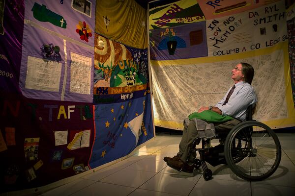 Michael Moore, of Lake Worth, looks at a display of squares from the AIDS Memorial Quilt at Compass in 2014. (Madeline Gray / The Palm Beach Post)