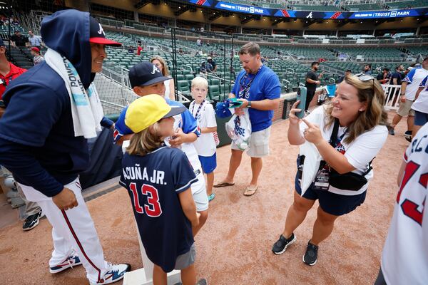 Sarah Scott from Atlanta takes a cellphone photo of her sons Hilton and Hunter Scott with Atlanta Braves pitcher Jesse Chavez (60) prior to the game between Atlanta Braves and Cincinnati Reds at Truist Park on Tuesday, July 23, 2024, in Atlanta.
(Miguel Martinez/ AJC)