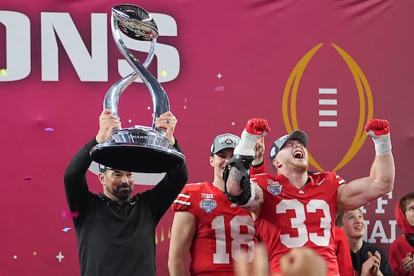 Ohio State head coach Ryan Day, left, celebrates with quarterback Will Howard (18) and defensive end Jack Sawyer (33) after the Cotton Bowl College Football Playoff semifinal game against Texas, Friday, Jan. 10, 2025, in Arlington, Texas. (AP Photo/Julio Cortez)