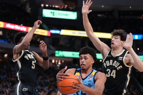 Marquette's Caedin Hamilton drives between Purdue's Myles Colvin and Raleigh Burgess during the first half of an NCAA college basketball game Tuesday, Nov. 19, 2024, in Milwaukee. (AP Photo/Morry Gash)