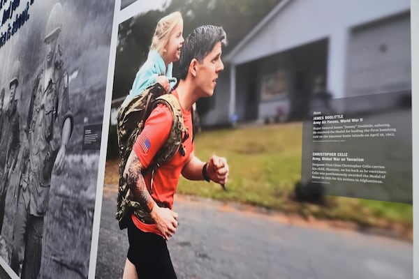 An image of Medal of Honor recipient Christopher Celiz jogging with his daughter, Shannon, in his backpack is on display at the National Medal of Honor Museum in Arlington, Texas, Thursday, March 13, 2025. (AP Photo/Tony Gutierrez)