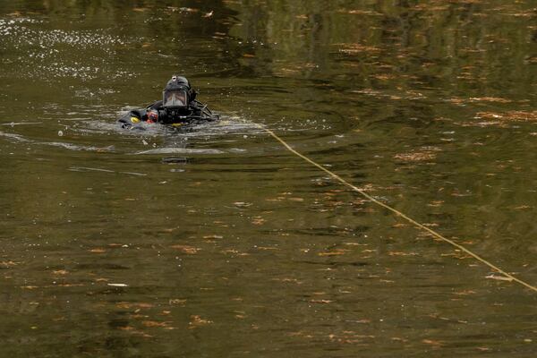 NYPD officers in diving suits search a lake in Central Park, Monday, Dec. 9, 2024, in New York. (AP Photo/Yuki Iwamura)