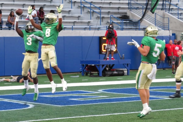 Buford Wolves running back Derrian Brown (3) celebrates his 25-yard touchdown run in the third quarter with Xyrie Wilson (8) as Seth Auer (5) looks on during their game against the Tucker Tigers on Friday, Aug. 17, 2018, at Georgia State Stadium in the 27th annual Corky Kell Classic. (Adam Krohn/special)