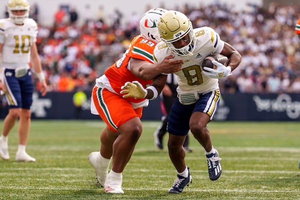 Miami defensive lineman Ahmad Moten Sr. (99) attempts to tackle Georgia Tech wide receiver Malik Rutherford (8) as he runs into the end zone during the first half of an NCAA college football game, Saturday, Nov. 9, 2024, in Atlanta. (AP Photo/Jason Allen)