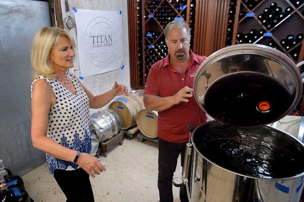 Kathy Loder, left, and her husband, Ron Loder, prepare to "rack" some of their wine at their home winery in Granite Bay, Calif., on July 26, 2017. (Randall Benton/Sacramento Bee/TNS)