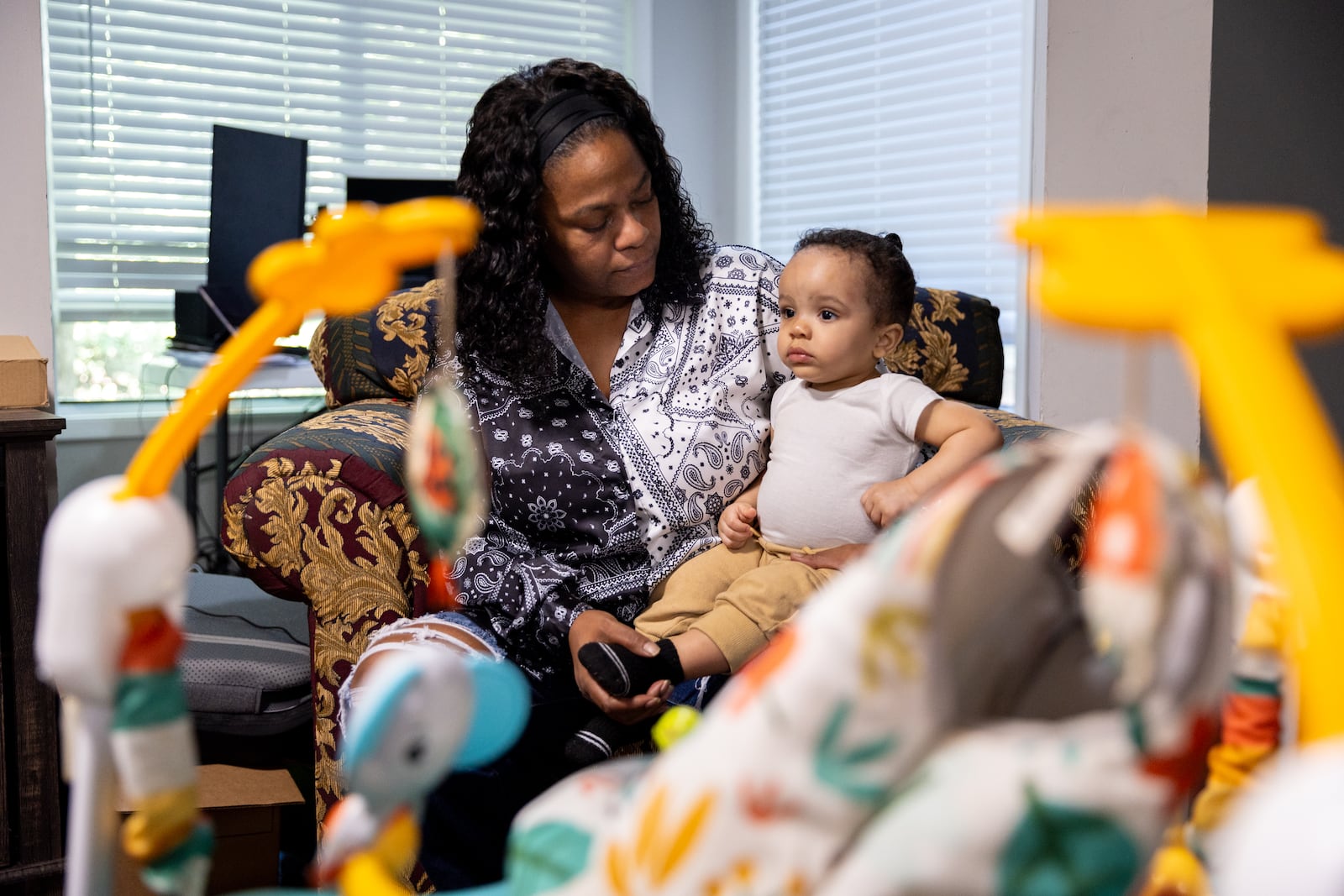 Quintes Comage holds her 13-month-old grandson, Misoul Richardson, at their apartment in Austell on Friday, October 11, 2024. (Arvin Temkar / AJC)