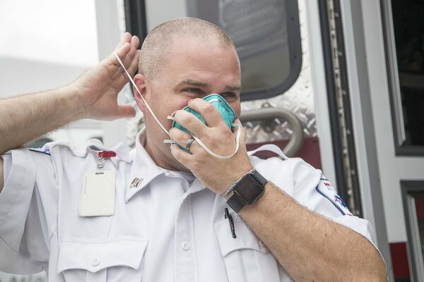 Anthony Zajac, clinical field supervisor at Metro Atlanta Ambulance Services, puts on protective gear for a demonstration of how crews will respond when transporting a patient with coronavirus. (ALYSSA POINTER/ALYSSA.POINTER@AJC.COM)