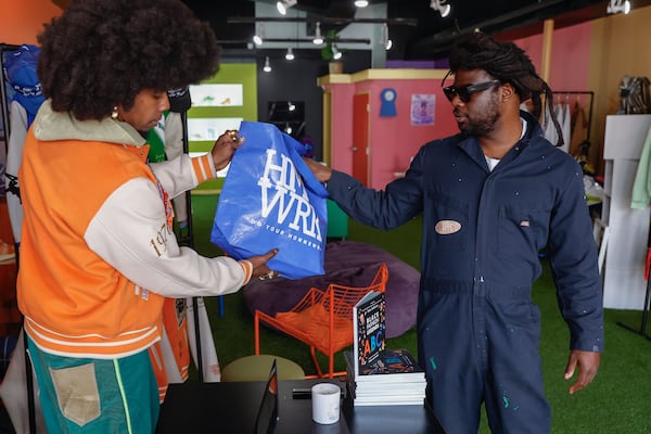 Atlanta rapper Trinidad James hands a shopping bag to customer Clayco Ryan at Hommewrk, his new boutique located inside Underground Atlanta on Friday, March 7, 2025. (Natrice Miller/ AJC)