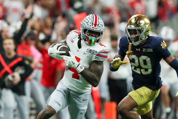 Ohio State wide receiver Jeremiah Smith (4) makes a 56-yard reception against Notre Dame cornerback Christian Gray (29) during the fourth quarter in the 2025 National Championship at Mercedes-Benz Stadium, Monday, Jan. 20, 2025, in Atlanta. Ohio State won 34-23. (Jason Getz / AJC)