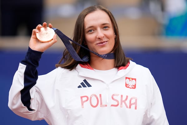 FILE - Poland's Iga Swiatek shows her bronze medal after the Women's Singles tennis final at the Roland Garros stadium at the 2024 Summer Olympics, Saturday, Aug. 3, 2024, in Paris, France. (AP Photo/Manu Fernandez, File)