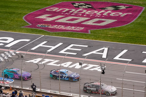 Ryan Blaney (12) Carson Hocevar (77) and Bubba Wallace (23) moves on the track during a NASCAR Cup Series auto race, Sunday, Feb. 23, 2025, in Hampton, Ga. (AP Photo/Mike Stewart)