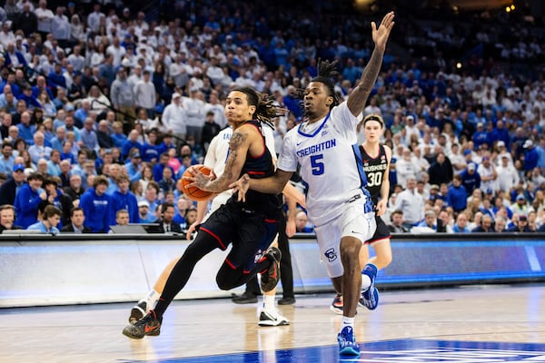 UConn guard Solo Ball, left, drives inside against Creighton guard Jamiya Neal (5) during the first half of an NCAA college basketball game, Tuesday, Feb. 11, 2025, in Omaha, Neb. (AP Photo/Bonnie Ryan)