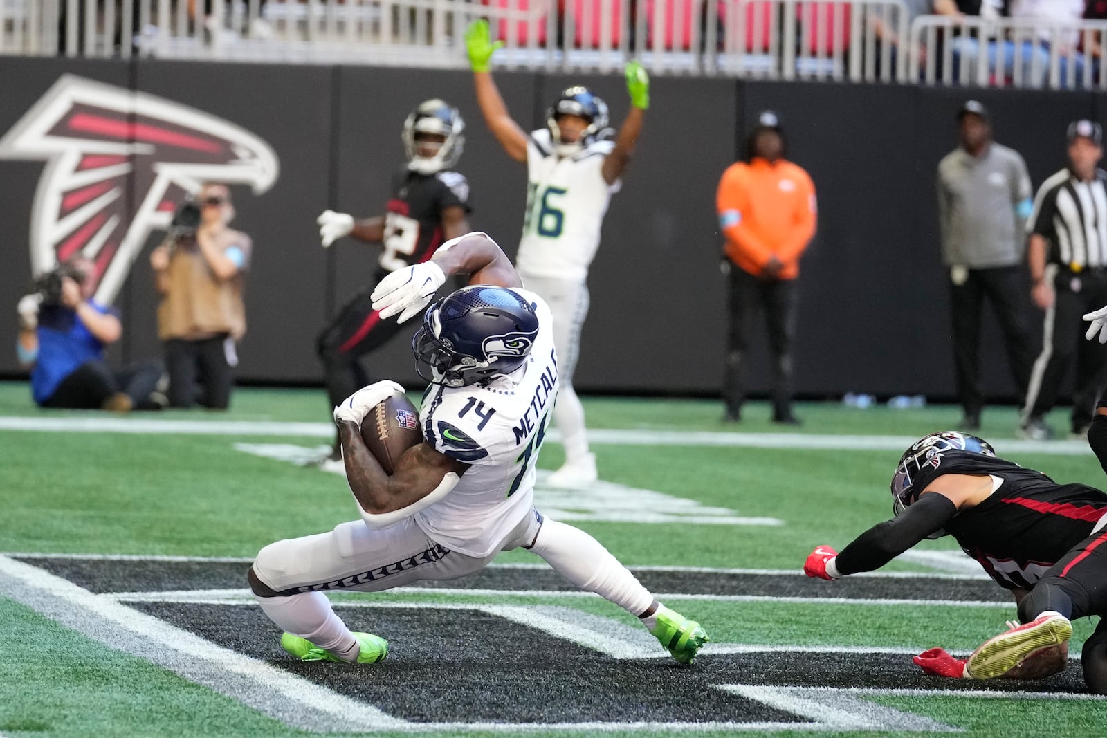 Seattle Seahawks wide receiver DK Metcalf (14) scors a touchdown as Atlanta Falcons safety Jessie Bates III (3) defends during the first half of an NFL football game, Sunday, Oct. 20, 2024, in Atlanta. (AP Photo/ Brynn Anderson)