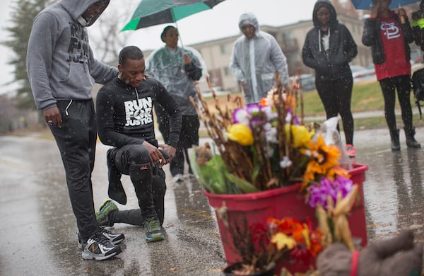 FERGUSON, MO - NOVEMBER 23: Ray Mills (L) and Londrelle Hall (2nd-L) view the Michael Brown memorial November 23, 2014 in Ferguson, Missouri. Mills and Hall spent nearly three weeks running from Atlanta, Georgia to draw attention to Brown's death. Brown, an 18-year-old black man, was killed by Darren Wilson, a white Ferguson police officer, on August 9. His death has sparked months of sometimes violent protests in Ferguson. A grand jury is expected to decide soon if Wilson should be charged in the shooting.. (Photo by Scott Olson/Getty Images)