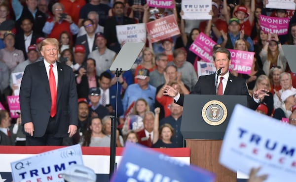 November 4, 2018 Macon - GOP gubernatorial candidate Brian Kemp speaks as President Donald J. Trump looks during President Donald J. TrumpÄôs Make America Great Again Rally to support Brian Kemp at Middle Georgia Regional Airport in MaconSunday, November 4, 2018. HYOSUB SHIN / HSHIN@AJC.COM