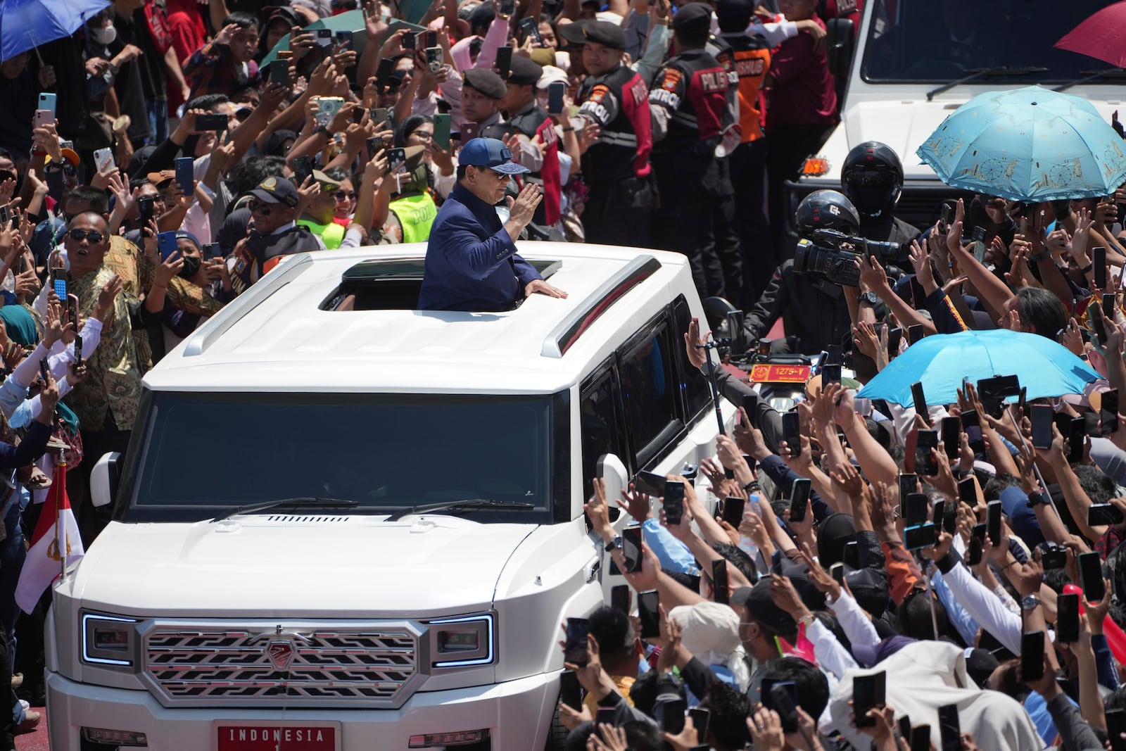 Newly-inaugurated Indonesian President Prabowo Subianto, center, greets supporters after being sworn in as the country's eighth president in Jakarta, Indonesia, Sunday, Oct. 20, 2024. (AP Photo/Dita Alangkara)