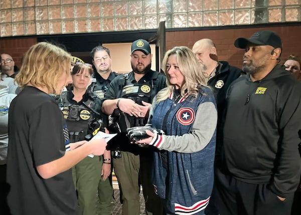 Andrew Collinson presents a flag to the family of Spalding County sheriff’s Sgt. Marc “Mac” McIntyre, who was killed in the line of duty.