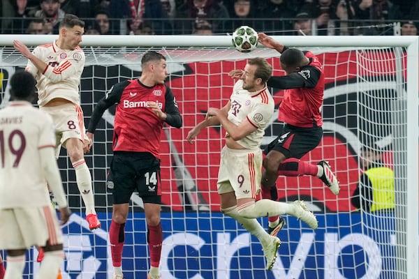 Bayern's Harry Kane, second right, heads the ball during the Champions League round of 16 second leg soccer match between Bayer Leverkusen and Bayern Munich at the BayArena in Leverkusen, Germany, Tuesday, March 11, 2025. (AP Photo/Martin Meissner)