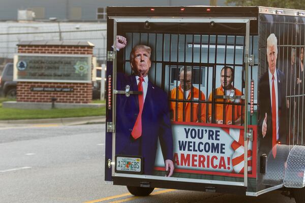 A truck pulling a trailer painted with pro-Trump messages drives back and forth in front of the Fulton County Jail Thursday morning, Aug. 24, 2023. (Steve Schaefer/steve.schaefer@ajc.com)