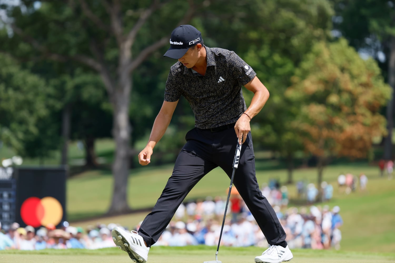 Collin Morikawa reaches for his ball after putting on the seventh green during the final round of the Tour Championship at East Lake Golf Club on Sunday, Sept. 1, 2024, in Atlanta.
(Miguel Martinez / AJC)