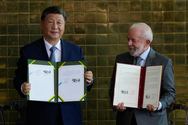 China's President Xi Jinping, left, and Brazil's President Luiz Inacio Lula da Silva pose for photos with their bi-lateral agreements at the Alvorada palace in Brasilia, Brazil, Wednesday, Nov. 20, 2024. (AP Photo/Eraldo Peres)