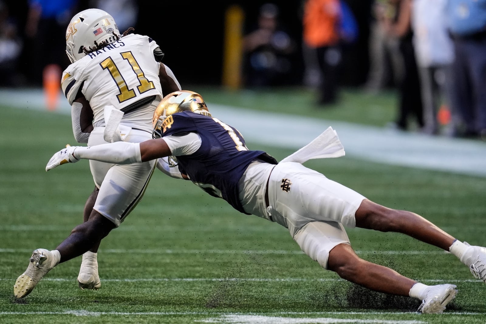 Georgia Tech running back Jamal Haynes (11) runs against Notre Dame cornerback Leonard Moore (15) during the first half of an NCAA college football game, Saturday, Oct. 19, 2024, in Atlanta. (AP Photo/Mike Stewart)