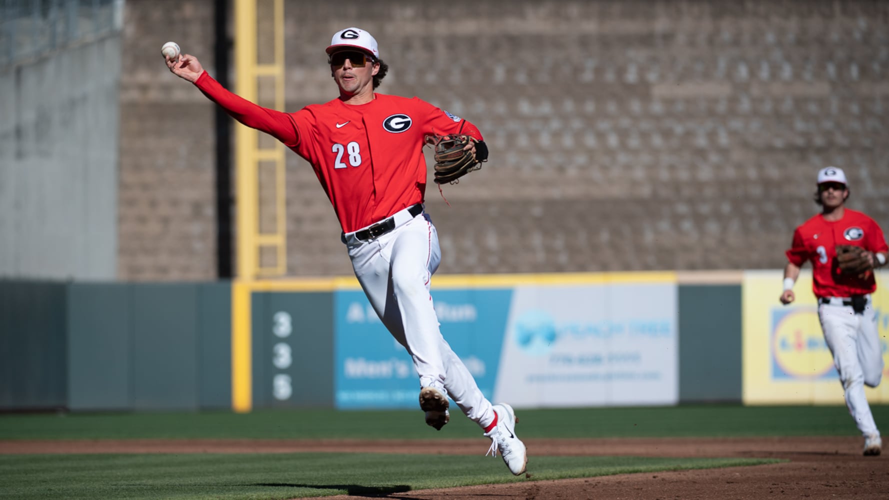 Bulldogs second baseman Will David throws the ball to first base during the 20th Spring Classic game against Georgia Tech on Sunday at Coolray Field in Lawrenceville. (Jamie Spaar / for The Atlanta Journal-Constitution)