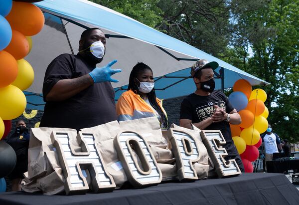 Killer Mike, T.I. and PAWkids founder and Executive Director LaTonya Gates pose for photos during a food distribution event Wednesday afternoon May 6, 2020 on Donald Lee Hollowell Parkway. Every Wednesday and Friday, PAWkids distributes 500 meals donated by Mercedes-Benz. (Ben@BenGray.com for theAJC)