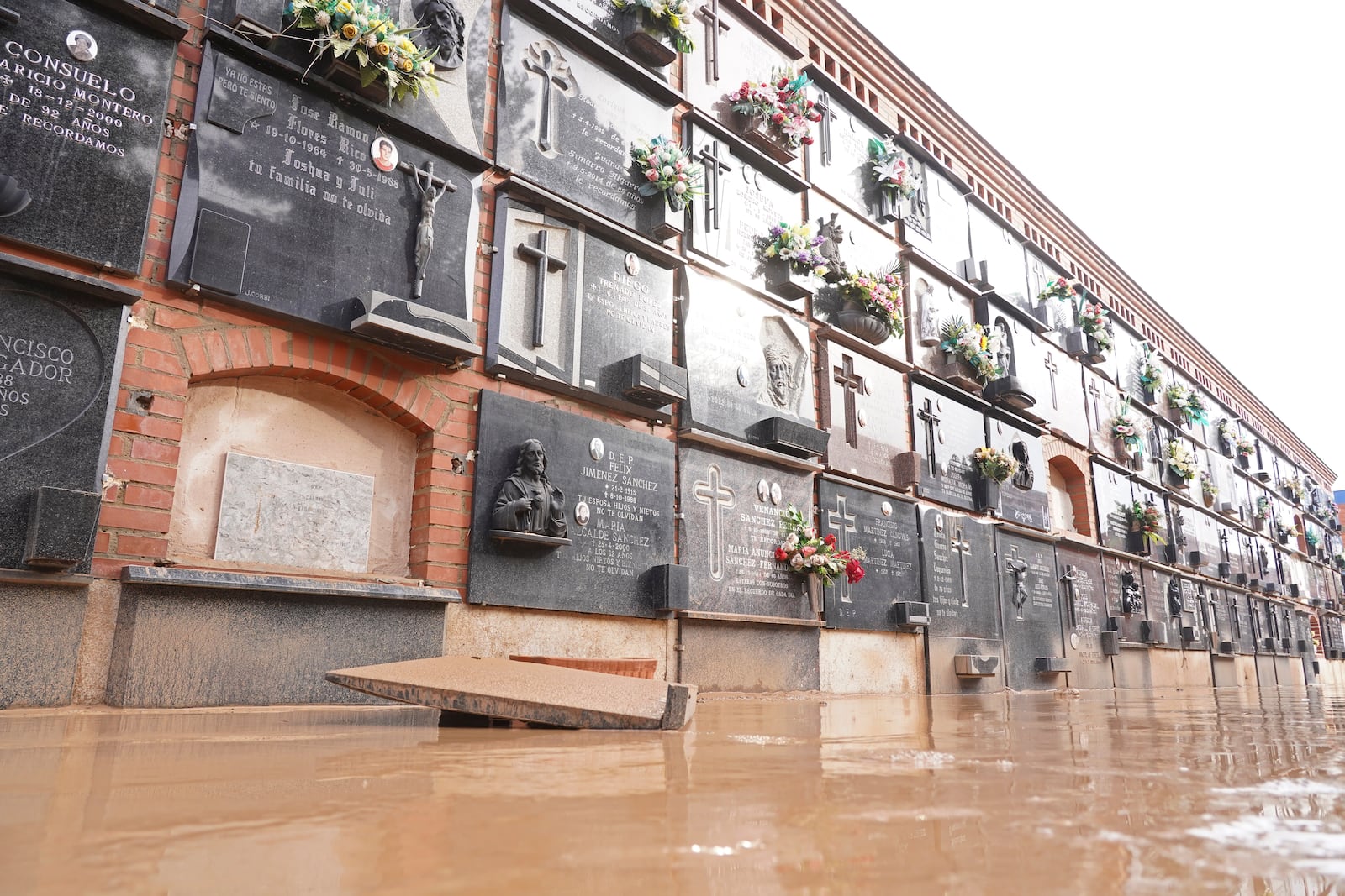 A flooded wall of tombs are seen inside a cemetery on the outskirts of Valencia, Spain, Friday, Nov. 1, 2024 after flooding in the region. (AP Photo/Alberto Saiz)