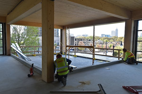 A construction crew works on a patio on the third level of T3 West Midtown at Atlantic Station. Mega developer Hines, which owns Atlantic Station, is hoping that its wood-frame design will appeal to young tech workers.