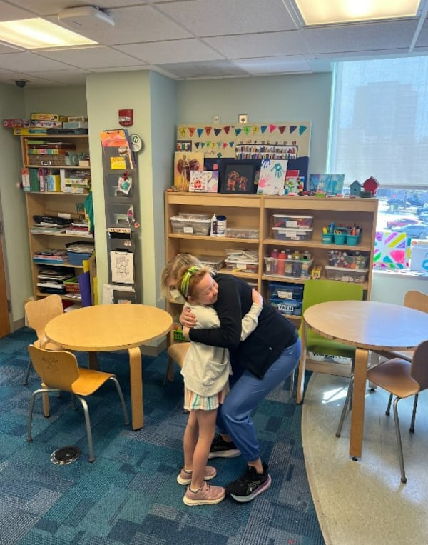 Virginia Bicksler hugs Hannah Randall, the artist in residence. Courtesy of the Bicksler family