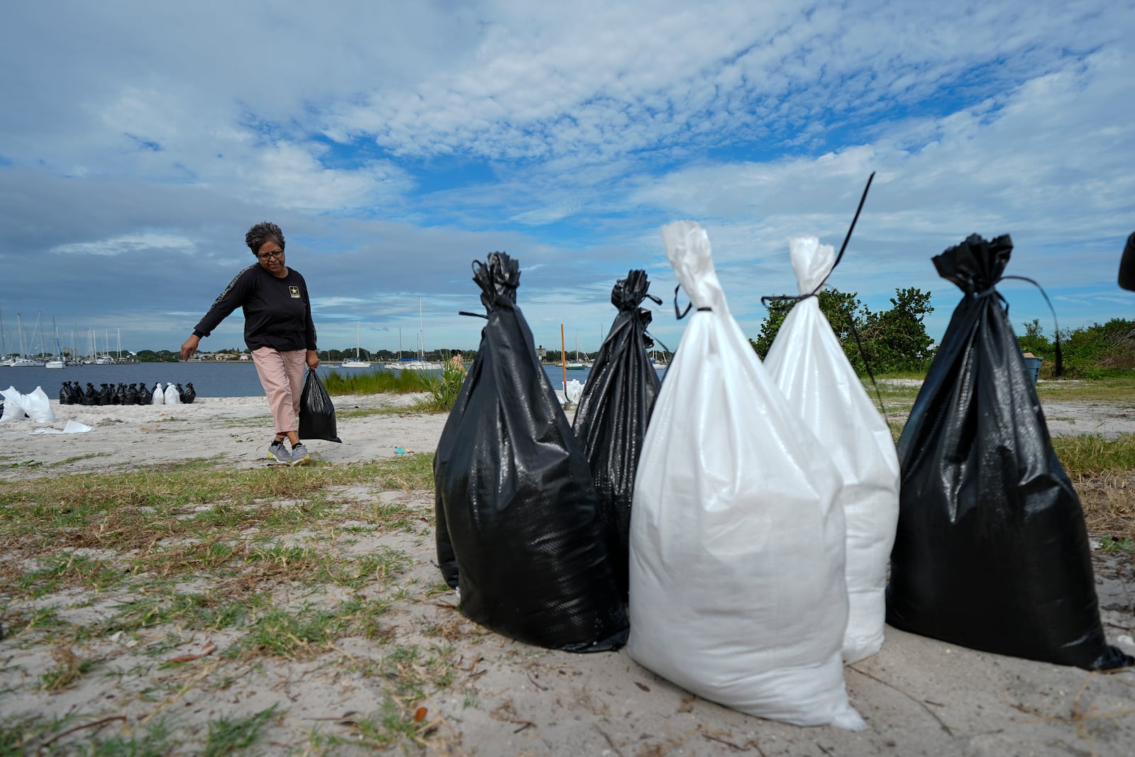 Susana Ortiz fills out sand bags on the beach at the Davis Islands Yacht Basin as she prepares for the arrival of Hurricane Milton, Tuesday, Oct. 8, 2024, in Tampa, Fla. (AP Photo/Julio Cortez)