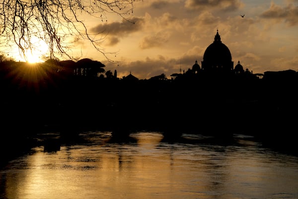 St Peter's Basilica at The Vatican is silhouetted as the sun sets across the river Tiber in Rome, Italy Friday, Feb. 28, 2025. (AP Photo/Kirsty Wigglesworth)