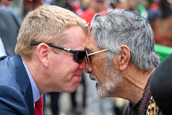 New Zealand's opposition leader Chris Hipkins, left, does a hongi with Hare Arapere as people gathered outside New Zealand's parliament to protest a proposed law that would redefine the country's founding agreement between Indigenous Māori and the British Crown, in Wellington Tuesday, Nov. 19, 2024. (AP Photo/Mark Tantrum)