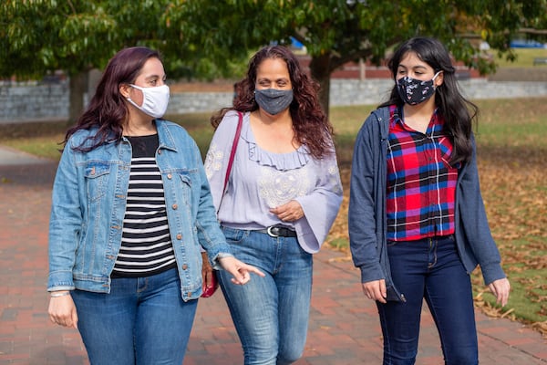 Lina Palancares, 24, Lina Van Bennekom, 46, and Mariana Palancares, 13, walk around Suwanee Town Center Park in Suwanee, Georgia, on Sunday, November 16, 2020. (Rebecca Wright for the Atlanta Journal-Constitution)