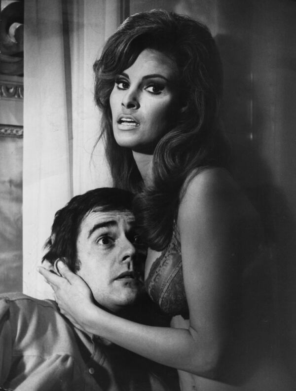 American actress Raquel Welch clutching a bemused Dudley Moore to her bosom in a comic scene from the film 'Bedazzled'.