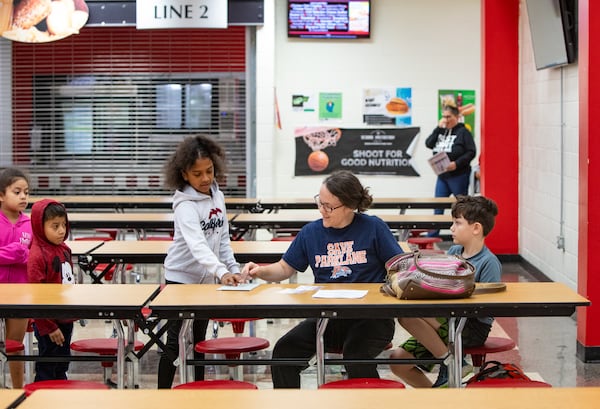 Christy Taylor and her son James Taylor gather at Tri-Cities High School on Wednesday, Nov 6, 2024 for a community information session about the possible closure of Parklane Elementary, where her children attend. (Jenni Girtman for The Atlanta Journal-Constitution)