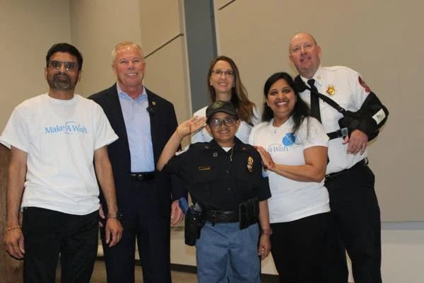 Arya Patel, saluting, with his father Paresh, mother Sangitaben, Cobb Public Safety Director Michael Register, Cobb Commissioner Keli Gambrill and Cobb Fire Department Chief Bill Johnson. (Photo Courtesy of Jake Busch)