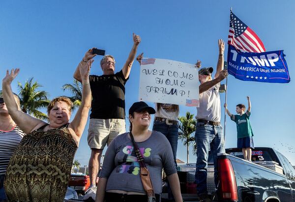 People cheer for President Donald Trump as he his motorcade passes by them on Southern Blvd. in front of the Publix in the Southdale Shopping Center, Feb. 3, 2017 in West Palm Beach. (Greg Lovett / The Palm Beach Post)