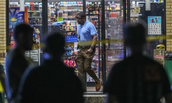 Investigators with DeKalb County police canvass the area of a BP gas station on Flat Shoals Road.