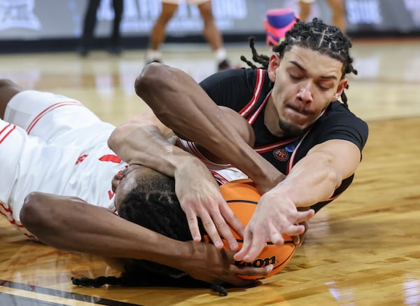 SIU Edwardsville forward Kyle Thomas, right, dives for a loose ball against Houston forward Joseph Tugler, left, during the first half in the first round of the NCAA college basketball tournament, Thursday, March 20, 2025, in Wichita, Kan. (AP Photo/Travis Heying)