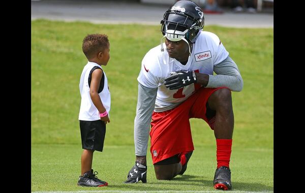 073115 FLOWERY BRANCH: Falcons wide receiver Julio Jones pauses to talk with a young fan as he leaves the field at the end of the first day of training camp on Friday, July 31, 2015, in Flowery Branch. Curtis Compton / ccompton@ajc.com