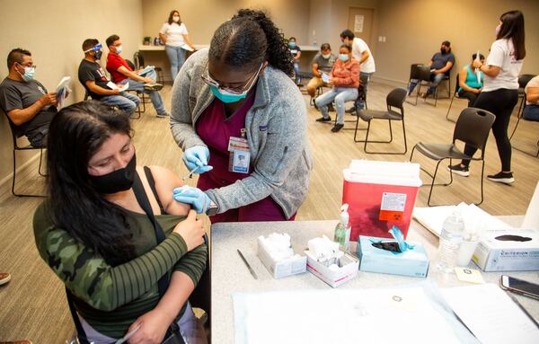 Fourth-year Morehouse School of Medicine medical student Nikki Jones administers a COVID-19 vaccine to Rosibel Nava Munivez at the Mexican Consulate in Atlanta earlier this week. (Steve Schaefer for The Atlanta Journal-Constitution)