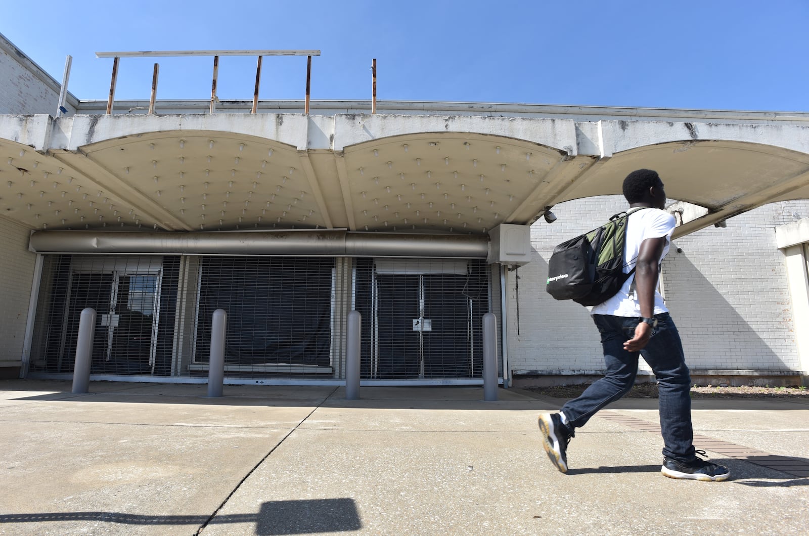 A pedestrian walks past an empty exterior at North DeKalb Mall earlier this month. HYOSUB SHIN / HSHIN@AJC.COM