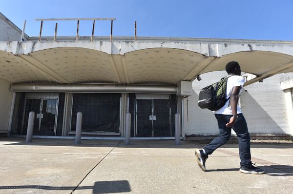 A pedestrian walks past an empty exterior at North DeKalb Mall earlier this month. HYOSUB SHIN / HSHIN@AJC.COM