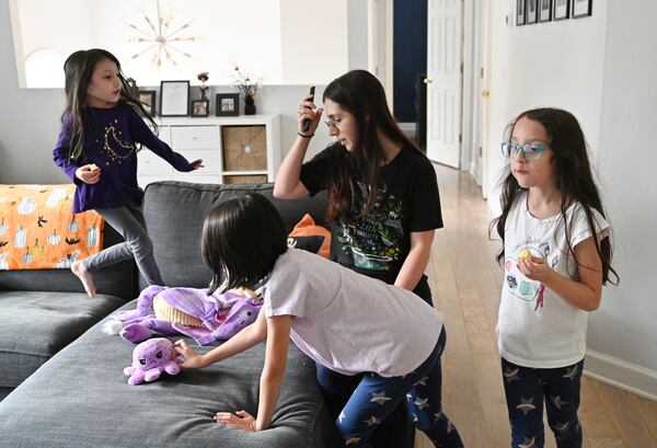 Mary Martinez turns on a television while her three daughters take a break from their homework at their home in Sugar Hill on Wednesday, October 6, 2021. (Hyosub Shin / Hyosub.Shin@ajc.com)